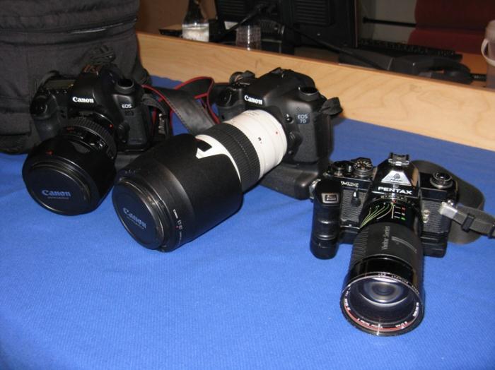 Ett par av de digitala systemkameror Gunnar Åkerberg använder i dag, från vänster, Canon EOS 5D mark II, Canon EOS 7D samt en av de första analoga systemkamerorna Gunnar använde från tidigt 80-tal och framåt. En gammal, men pålitlig, helmanuell Pentax MX. Foto: Hans Groby.