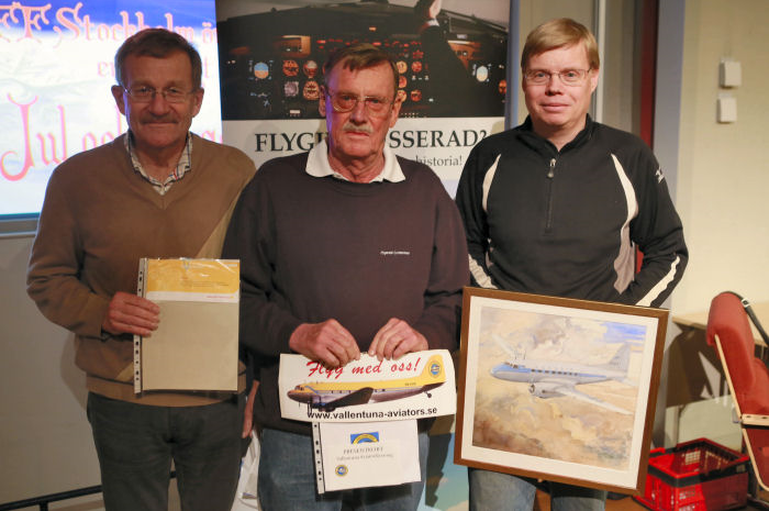 Vinnarna av högvinsterna i jullotteriet uppradade: Bengt Lindgren vann en tur och retur-flygning med Malmö Aviation, Peter Lindström vann en rundflygning med Vallentuna Aviators DC-3 Congo Queen och Lars Andersson vann en vacker akvarellmålning föreställande Saab Scandia SE-BCA av konstnären Jan-Olov Andersson. Foto: Foto: Thorsten Fridlizius.