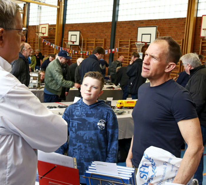 Bernt Olsson från SFF Stockholm informerar ett par besökare om Svensk Flyghistorisk Förenings verksamhet i SFF:s monter. Foto: Gunnar Åkerberg  