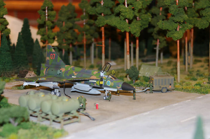 Hans Fehrnström realistiska diorama av Underrättelsepluton S37. Dioramat föreställer en underrättelsepluton från F13 som var grupperad på Eskilstunabasen tidigt 80-tal. En komplett klargöringsplats grupperad i ”bakom”. Med modeller av SF 37/SH 37 och många scratchbyggda modeller av utrustning och fordon som tillhör basen. Denna modell visar på ett  utomordentligt bra sätt hur en underrättelsepluton grupperade och där samtliga komponenter och fordon ingår. Foto: Johan Tilosius.