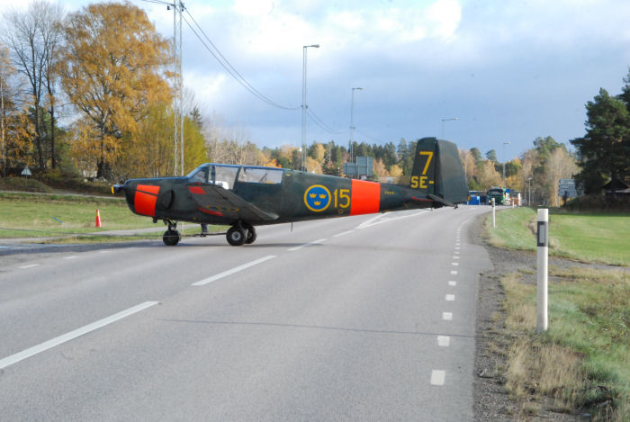 SAAB Safir 91B taxar över en väg på väg mot vinterförvaring i en hangar som ligger lite avsides från flygfältet i Vallentuna. Notera hastighetskameran vid sidan av vägen. Någon hastighetsöverträdelse lär det dock inte vara i detta fallet. Foto: Bengt Simson