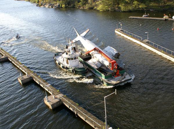 En pråm kommer lastad med Munin. Observera den lilla jollen som nästan höll på att köra in i bryggan när han förvånad mötte den udda transporten! Foto: Sture Friedner.