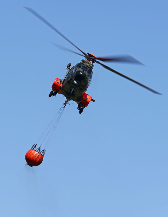 Besättningen manövrerar in H-97 för att fälla ännu en omgång med vatten på brandhärden. Foto: Gunnar Åkerberg.