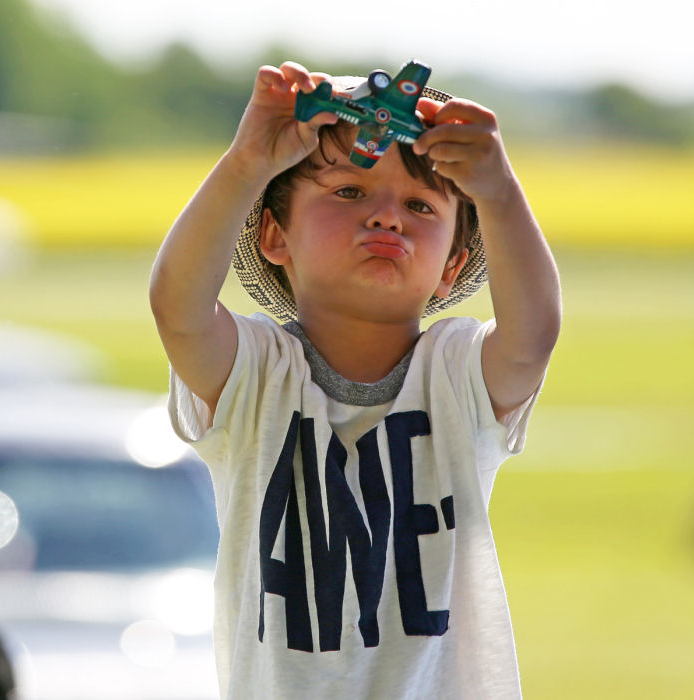 Denna unga besökare var helt uppslukad av det lilla modellplanet och atmosfären på Veterandagen 2015. Texten på hans T-shirt: ”AWESOME” säger väl allt! Foto: Gunnar Åkerberg